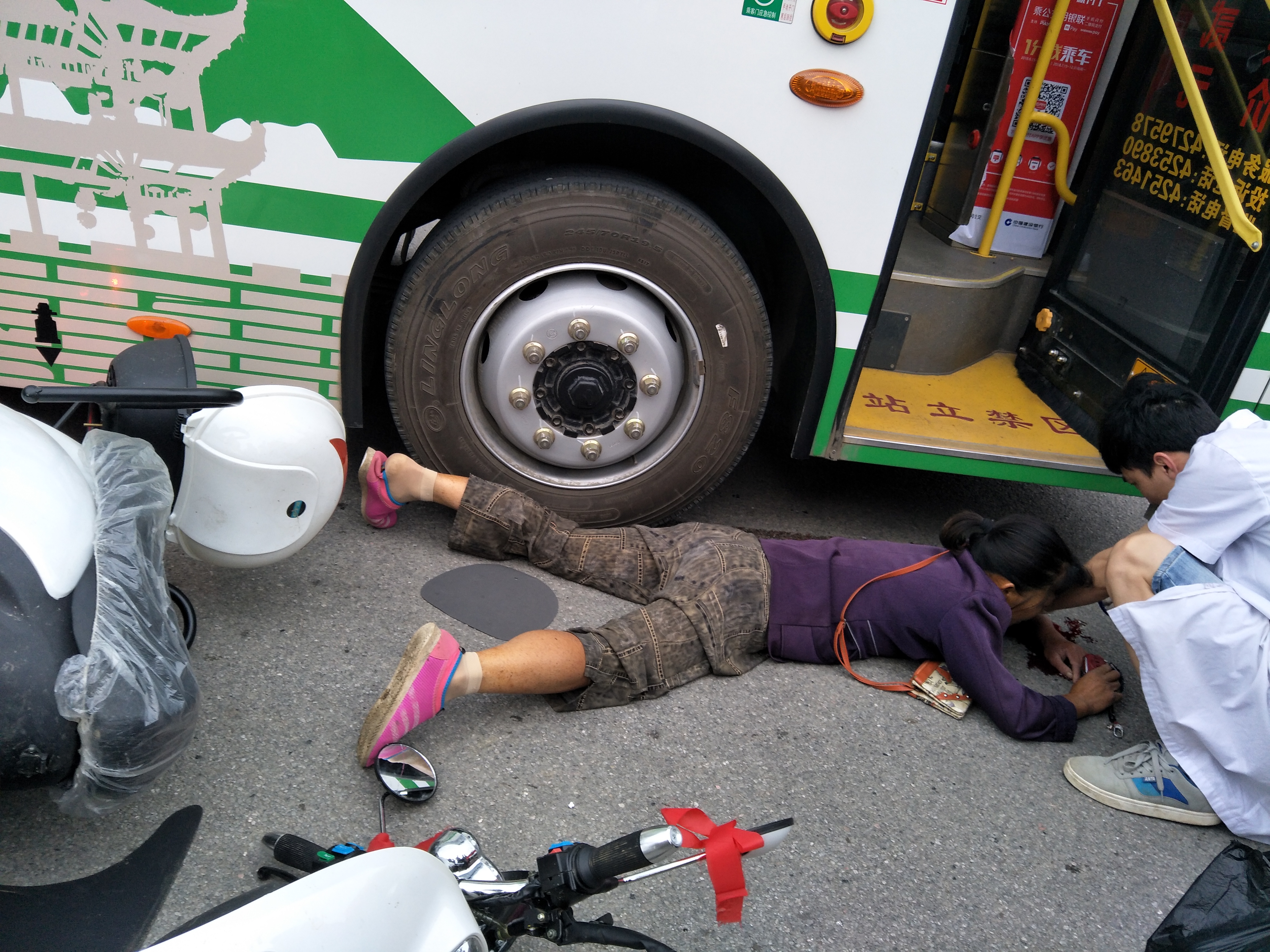 武冈一妇女被公交车撞到在地，现场好多血...